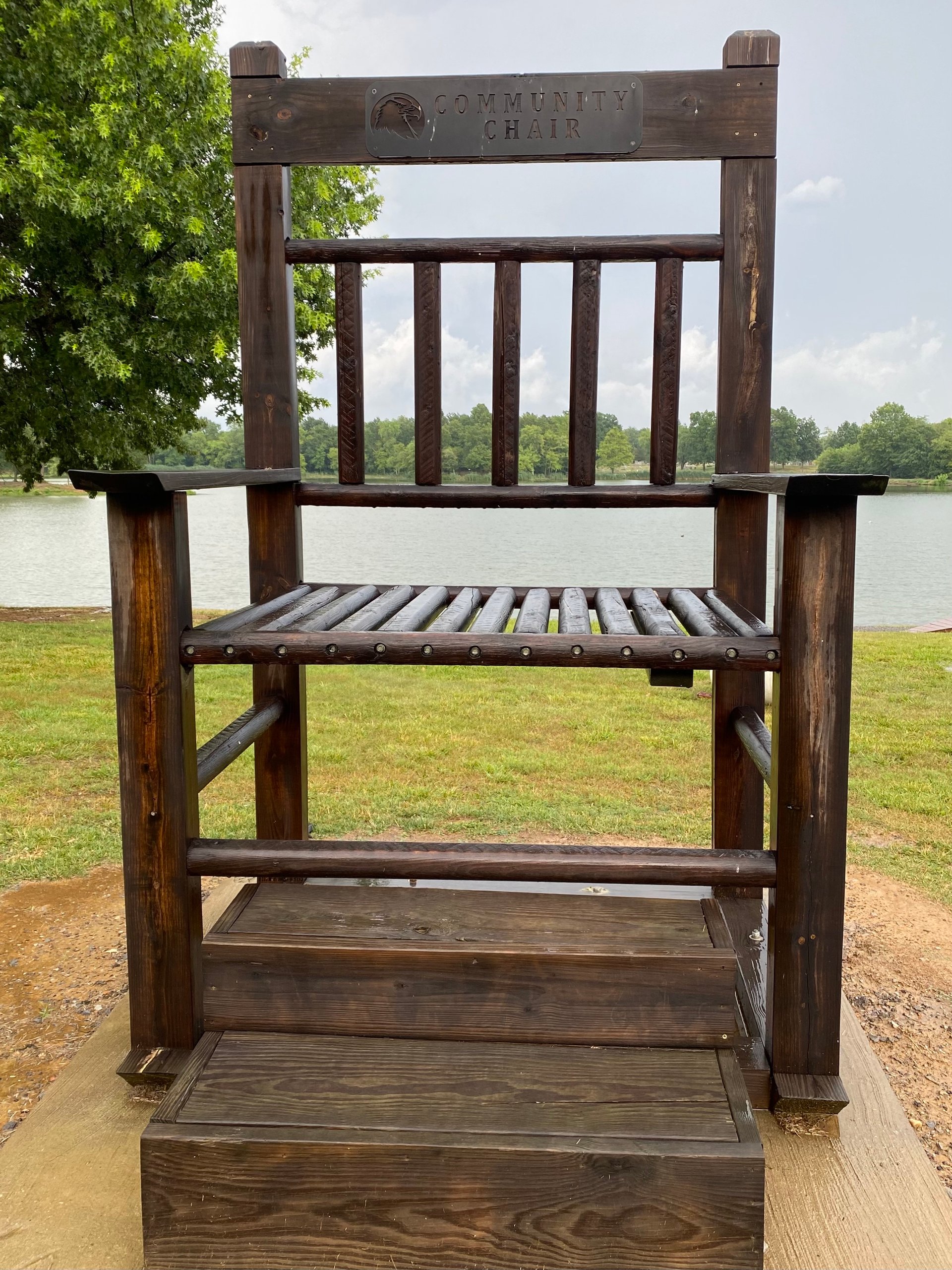 Oversized chair on the lakefront for photos labeled Community Chair.